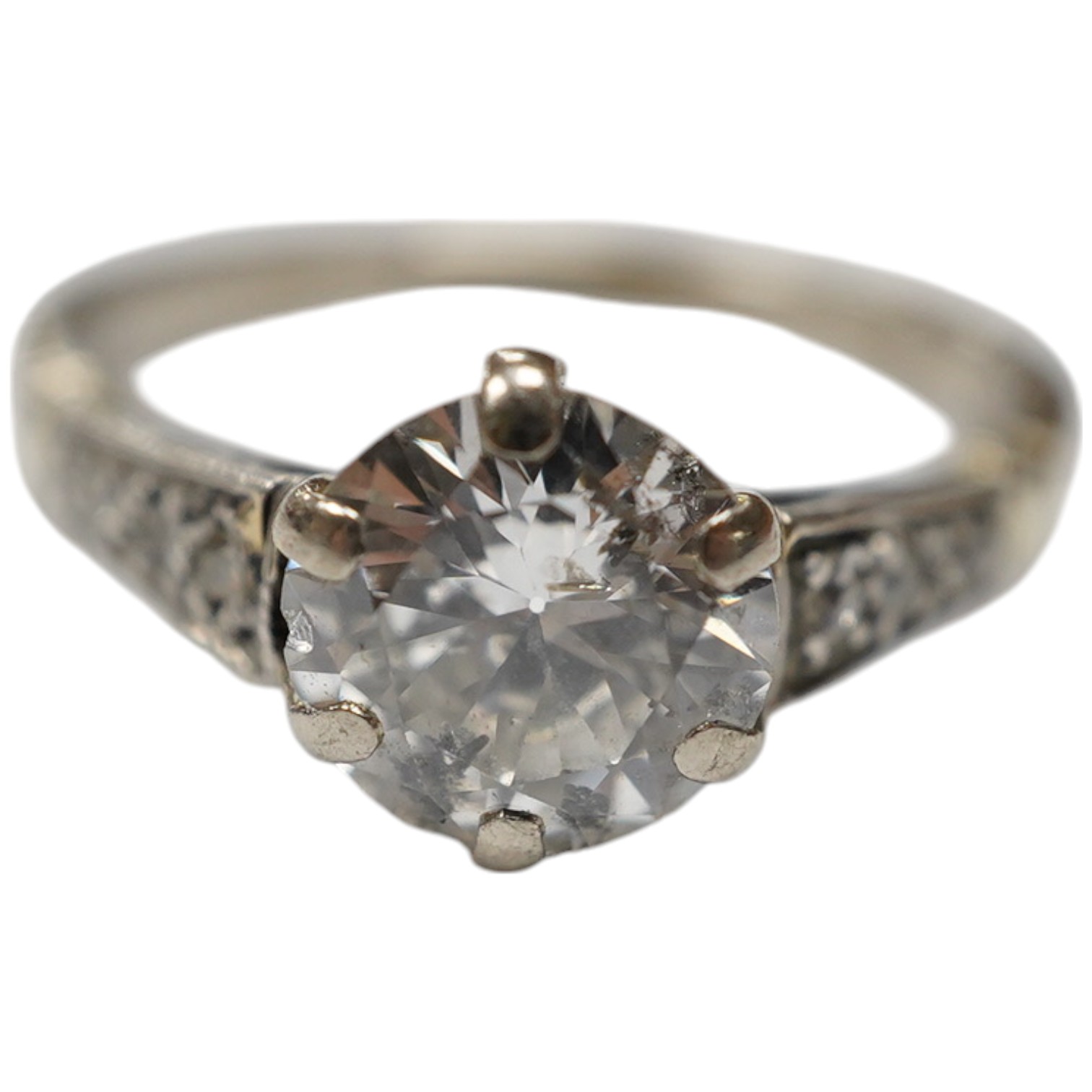 A white metal (stamped 18ct) and single stone diamond set ring, with six stone diamond set shoulders, the central stone weighing approximately 1.10ct, size M, gross weight 3.7 grams. Condition - poor to fair.